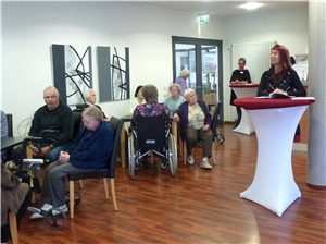 Die Vernissage in der Cafeteria mit Besuchern, der Künstlerin und der Einrichtungsleiterin. Vernissage 2