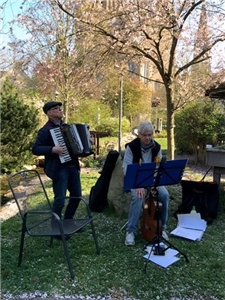 eim Gartenkonzert sorgten Peter Stadler und Gerhard Kief mit Akkordeon und Gitarre für musikalische Unterhaltung der Bewohner*innen, die von ihren Balkonen aus zuhörten. t