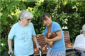Jana Herbert nimmt ein Huhn auf den Arm