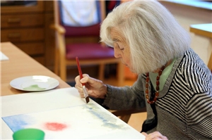Eine Frau malt. Kunsttherapie Teilnehmerin