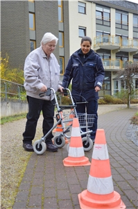 Eine Bewohnerin durchläuft mit ihrem Rollator einen Parcours. Rollatorentraining 2 hoch