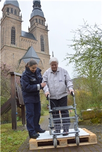 Eine Bewohnerin von St. Martha wird von der Polizeibeamtin beim Training mit dem Rollator gestützt. Rollatorentraining hoch