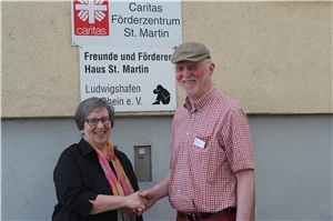 kfd-Dekanatsvorsitzende Doris Demessier (links) und Leiter Stefan Syren vor der Hauswand mit dem Schild vom Caritas-Förderzentrum St. Martin. 