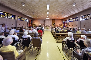In der Kapelle sitzen rechts und links vom Gang die Besucher und sehen nach vorne zum Altar. Profanierung der Kapelle 1
