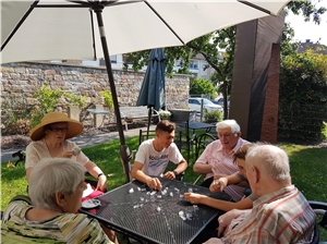 Bewohner und ein Schüler, der zurzeit in Sozialpraktikum absolviert, schossen sich gegenseitig die Eiswürfel auf der Tischplatte zu. Eiswürfelschießen 1