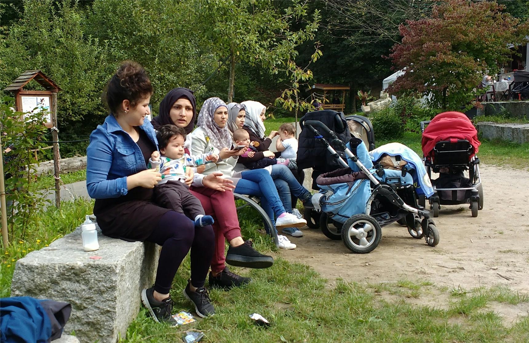 Mehrere Frauen und mit kleinen Kindern machen beim Ausflug für geflüchtete Frauen eine Pause. 