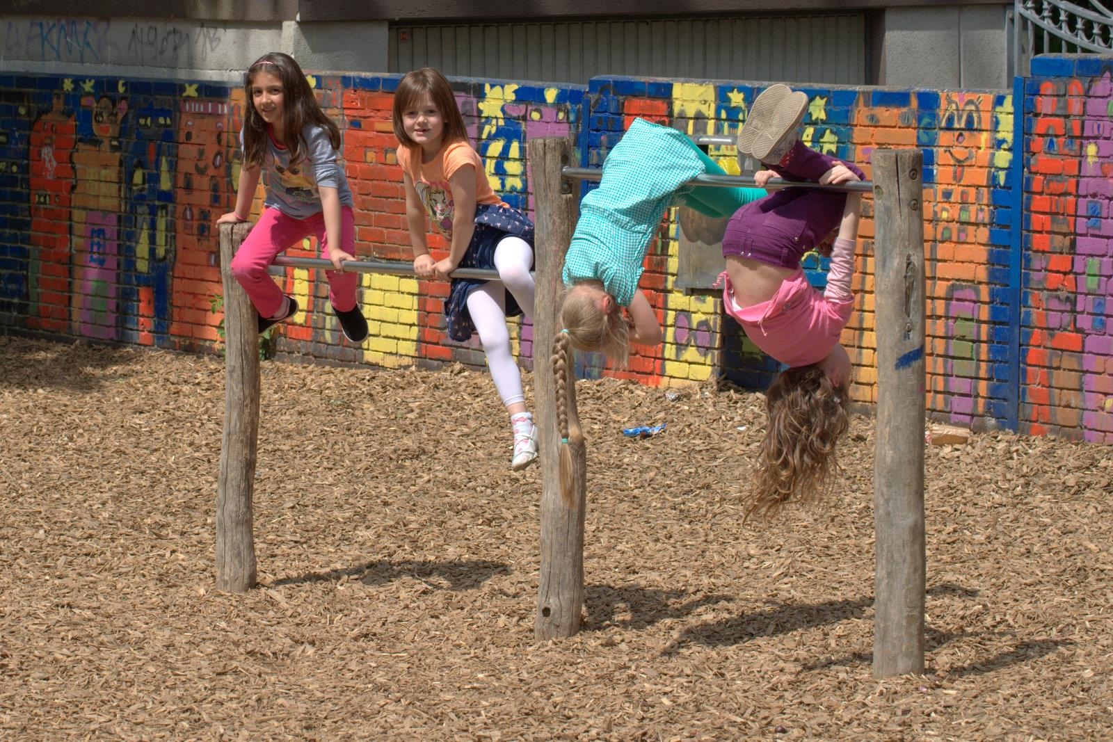 Vier Mädchen turnen an einer Kletterstange. 