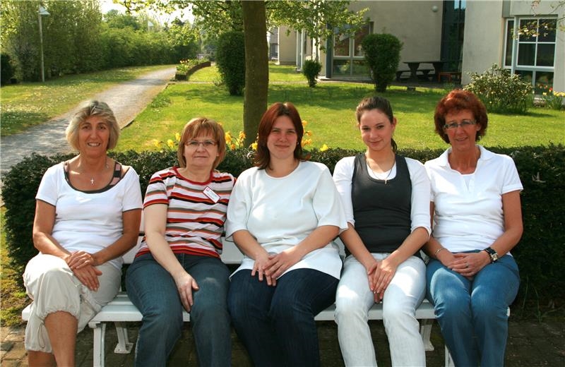 Fünf Mitarbeiterinnen auf einer Bank 