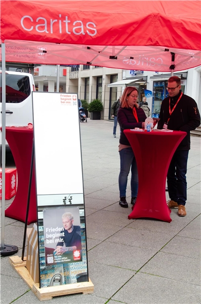 Eine Frau und ein Mann unter einem roten Pavillon an einem roten Tisch mit einem Spiegel in der Stadt Saarbrücken
