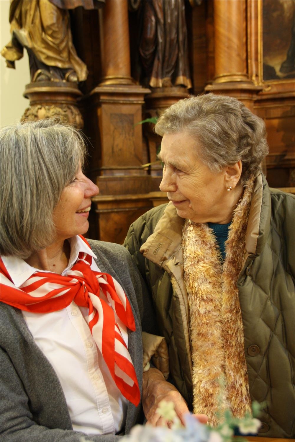 Zwei Damen schauen sich während eines Gottesdienstes an (Foto: Malteser Hilfsdienst)
