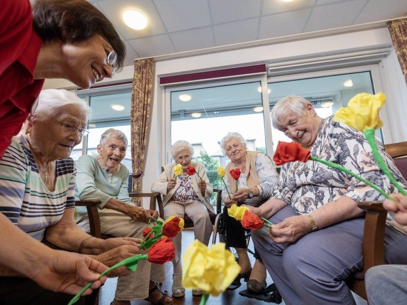 Seniorinnen im Stuhlkreis mit Papierblumen 