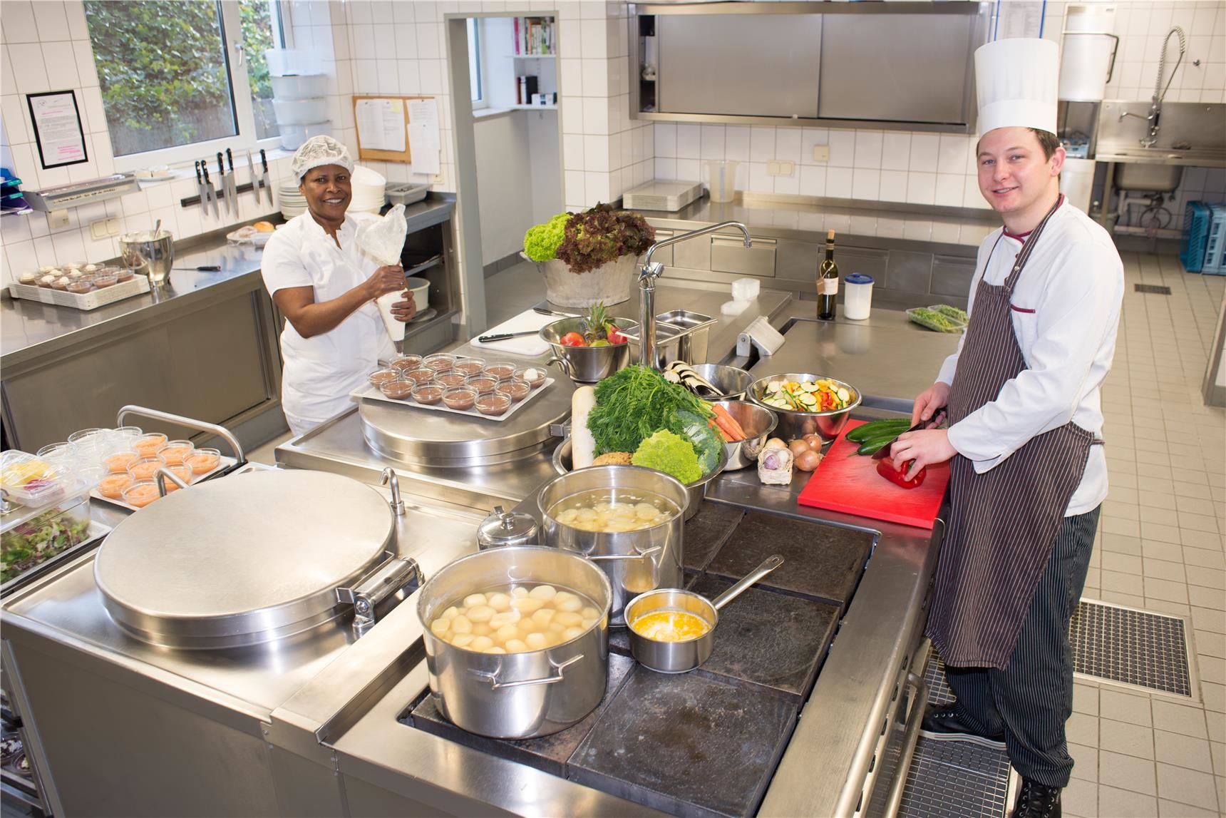 Koch und Beiköchin in einer großen Küche (Udo Keus)