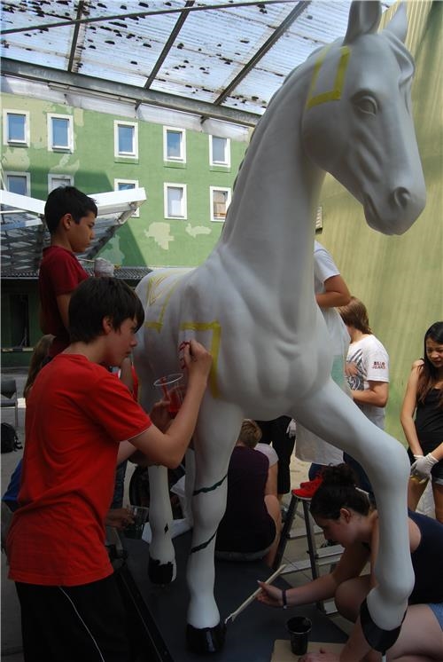 Jungs malen Konturen der Motive auf das Pferd (Caritas Speyer)