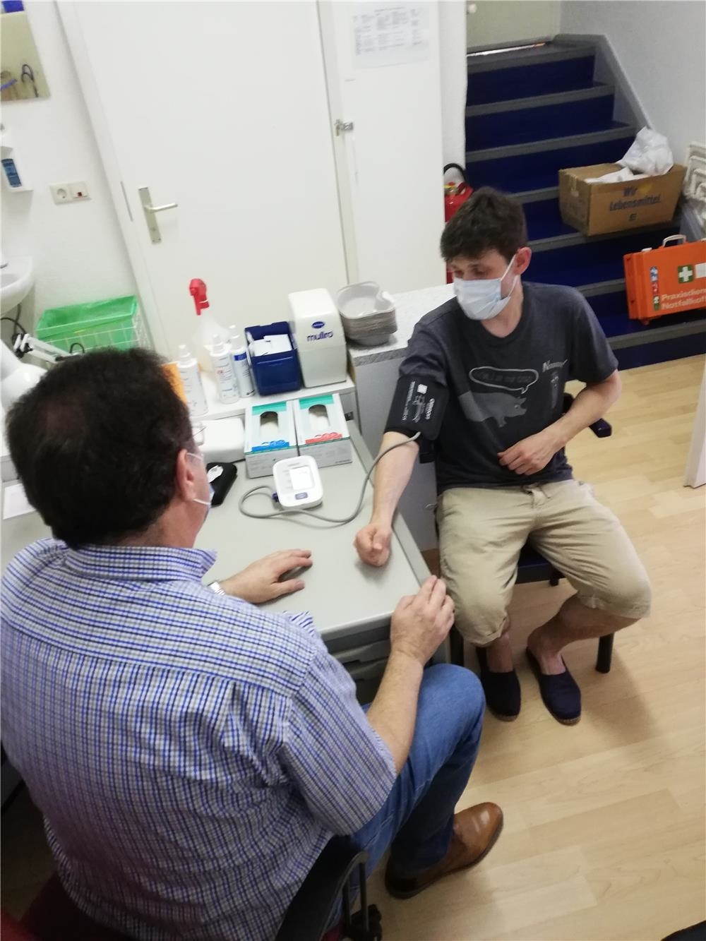 Ein ehrenamtlich arbeitenden Arzt misst Blutdruck bei einem Klienten (Foto: Caritasverband Worms e.V.)