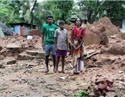 Familie vor zerstörtem Gebäude / Foto: Caritas Indien