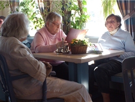 Drei Bewohnerinnen sitzen zusammen am Tisch in einem Café. / Mario Horn