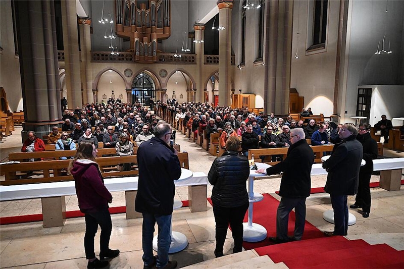 Blick über fünf Personen bei der Podiumsdiskussion in der Herz-Jesu-Kirche Oberhausen in den voll besetzten Kirchenraum.
