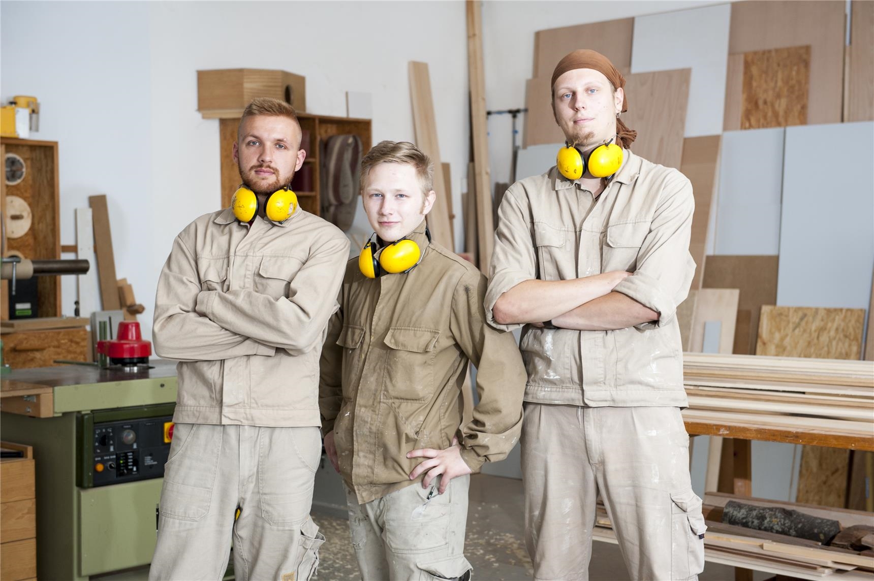 Drei junge Männer in Arbeitskleidung in der Jugendwerkstatt Holztechnik der CJS Hannover (Ina Funk)
