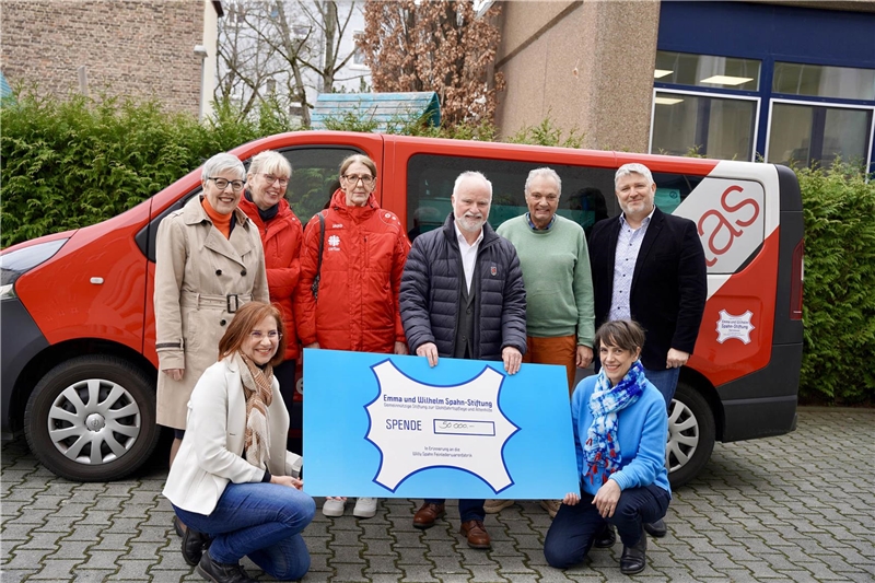 Vertreter der Spahn-Stiftung überreichen vor dem Ambulanzbus einen großen Scheck an die Caritas Straßenambulanz Offenbach