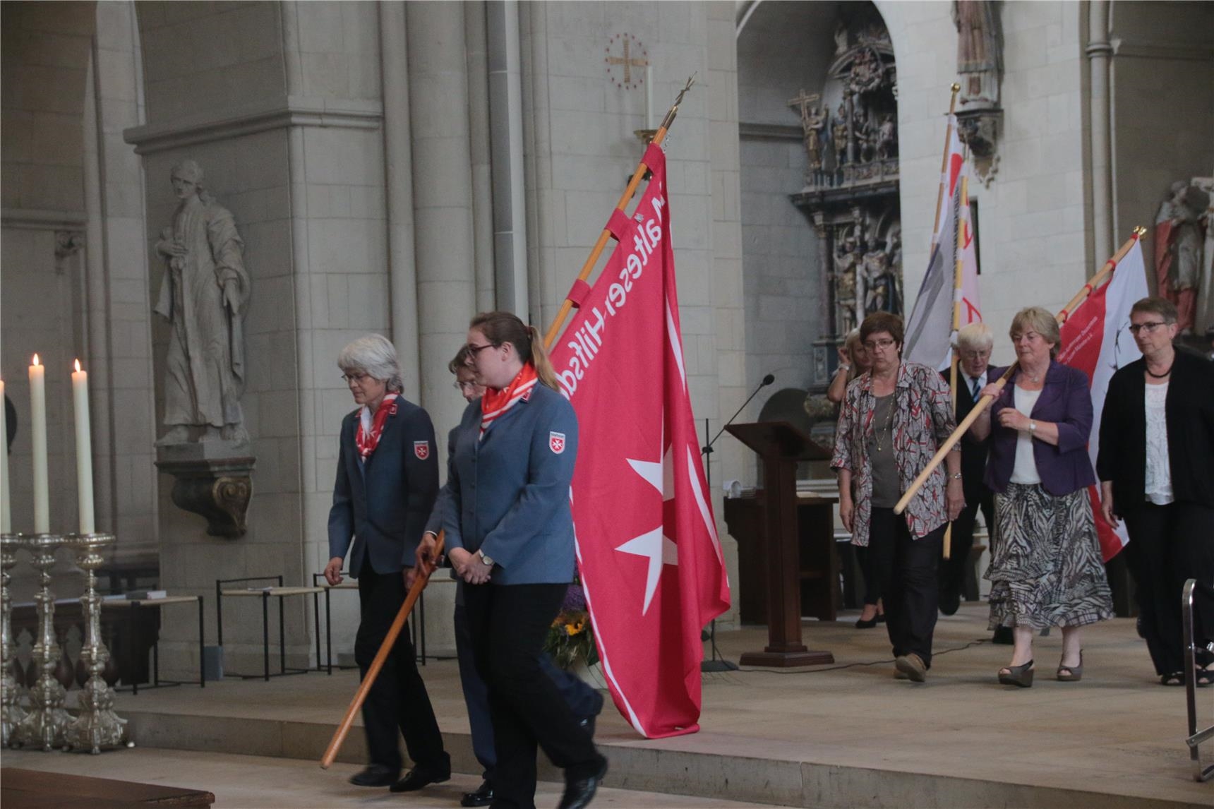 Das Foto zeigt Kleingruppen von Menschen, die mit großen Bannern aus dem Dom ziehen. (Harald Westbeld)