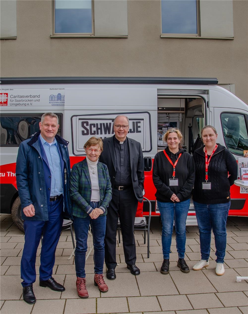 Zwei Männer und drei Frauen stehen vor einem modernen Camper mit dem Aufdruck Schwätzje Mobil (Caritasverband für Saarbrücken und Umgebung e.V. (Götz Plettke)