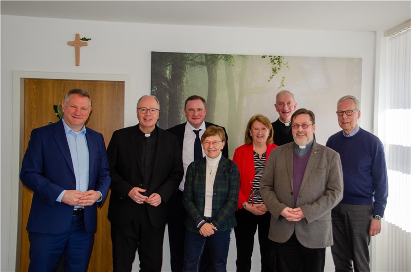 Gruppenbild von sechs Männern und zwei Frauen beim Besuch des Bischofs
