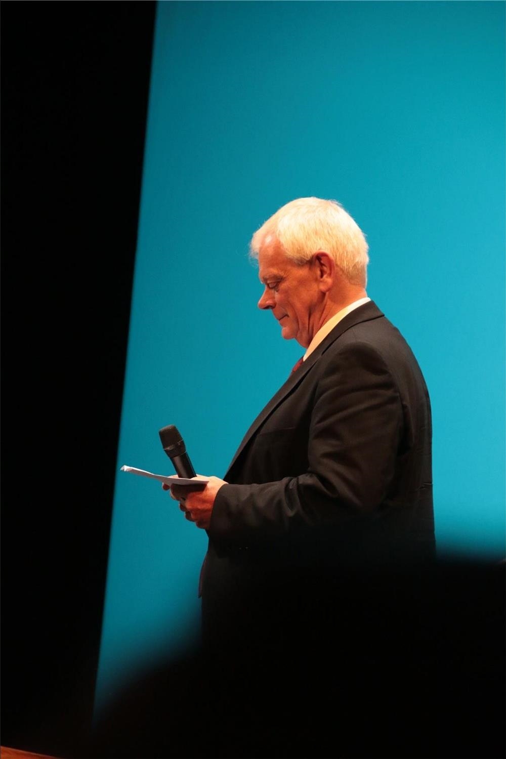 Das Foto zeigt einen Mann auf einer Bühne vor blauem Hintergrund. (Harald Westbeld)