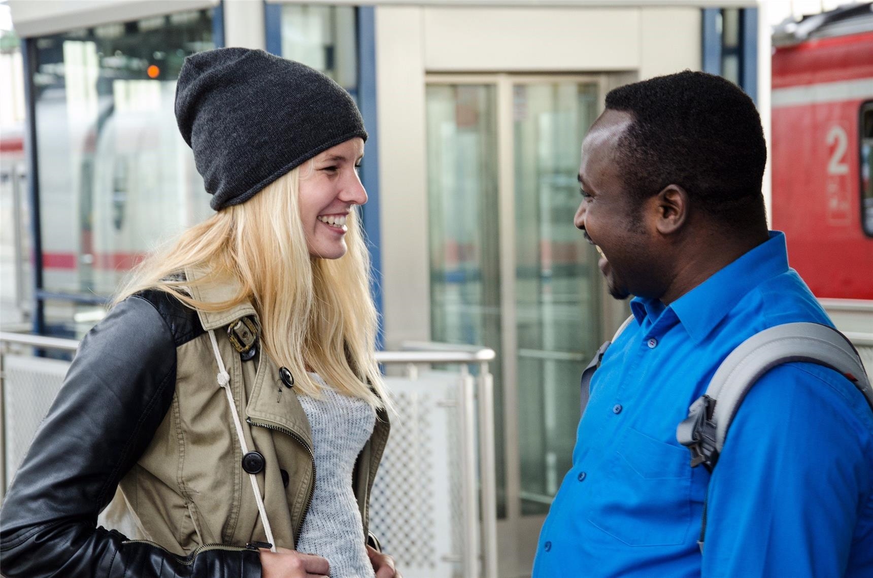Freundliche Begegnung am Bahnsteig: Sie lässt einen Flüchtling auf ihr Ticket mitfahren. (   Caritas / Rebacca Radmacher)