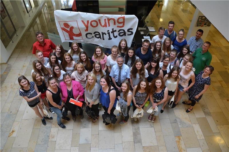 Gruppenfoto der Jugendlichen mit Plakat von youngcaritas (youngcaritas Deutschland)