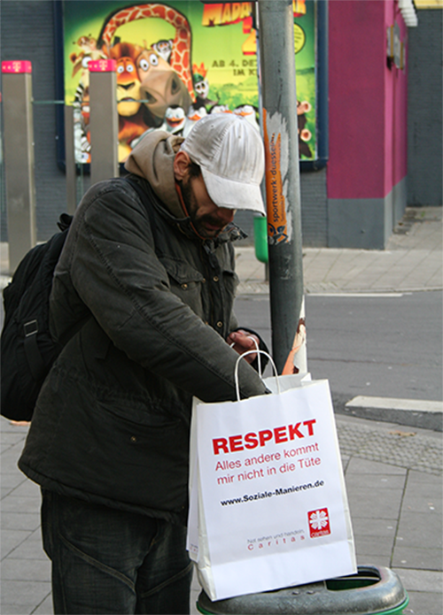Ein Obdachloser kramt in einer Respekttüte (Markus Lahrmann)