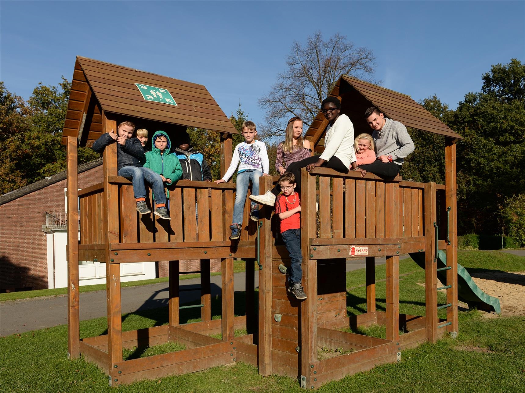 Kinder klettern auf das Spielhaus aus Holz (Petra Lamers)