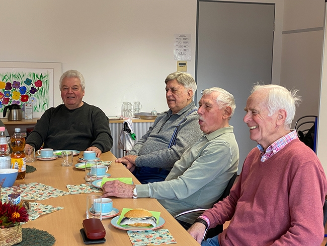 4 Männer am Tisch im Gespräch (Caritasverband Darmstadt e. V.)