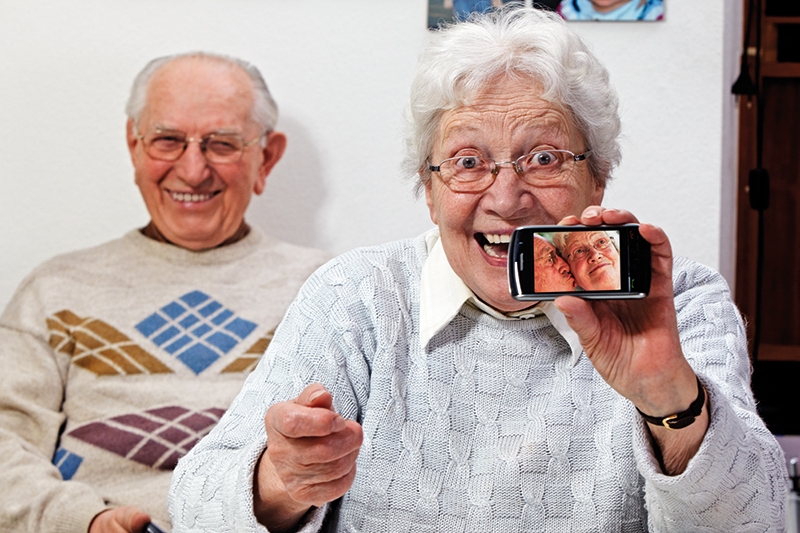 Seniorenpaar macht Fotos mit dem Mobiltelefon