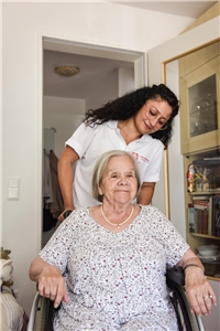 Pflegerin schiebt Pflegebedürftige im Rollstuhl