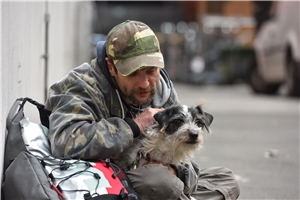 obdachloser Mann streichelt seinen Hund