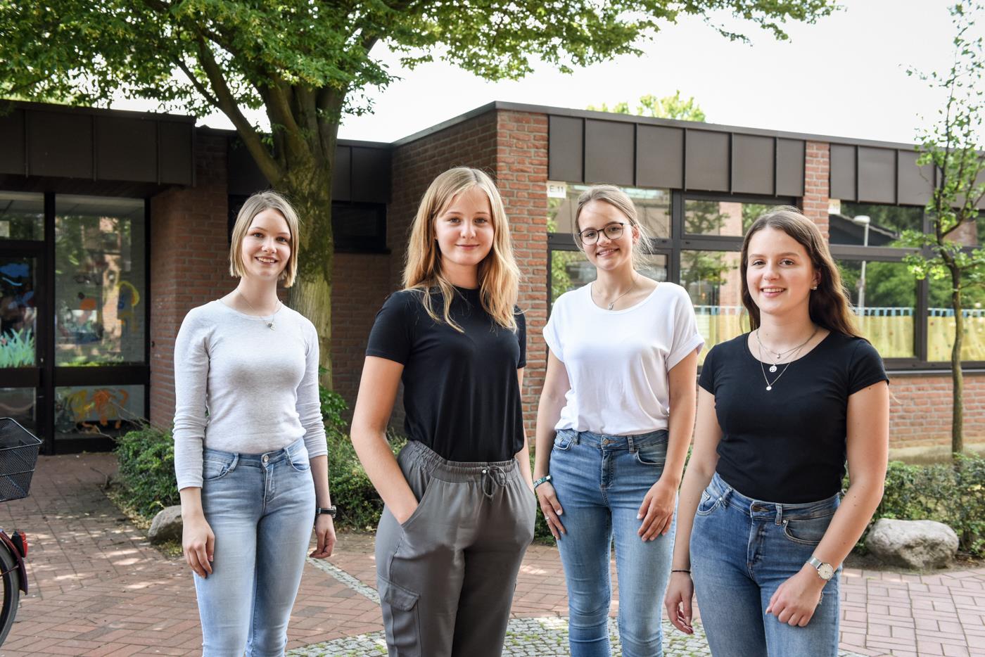 Vier junge Frauen blicken in die Kamera