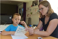 Homeschooling in der Corona-Zeit Mutter lernt mit Sohn die Buchstaben mithilfe einer Schablone