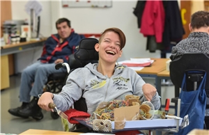 lachende Frau im Rollstuhl in Werkstattt für MmB