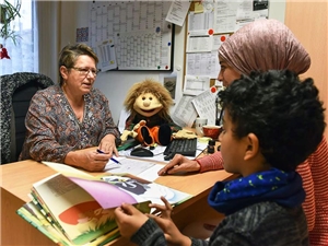 Migrationsberatung Beraterin berät in ihrem Büro Frau mit Kopftuch und ihr Kind