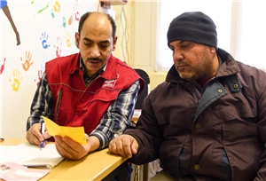 Aufnahme eines Asylbewerbers in einem Asylbewerberheim durch einen Mitarbeiter der Caritas