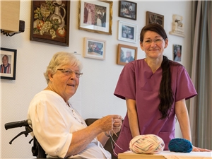Pflegerin und Seniorin Eine Pflegerin spricht mit einer Seniorin.