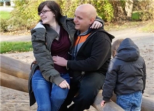 Schwangere mit Kind und Mann auf dem Spielplatz