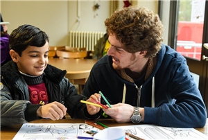 Mann mit Kind in Schulzimmer