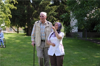 Alter Mann mit Pflegerin im Garten