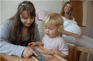 junge Frau mit Kleinkind am lesen