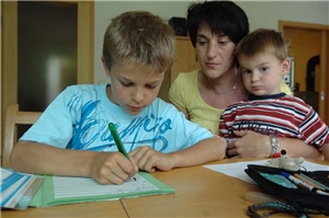 Mutter mit Kindern bei den Hausaufgaben 