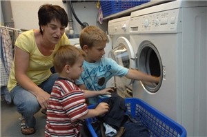 Mutter mit ihren Söhnen vor der Waschmaschine