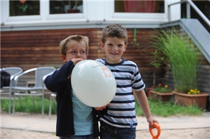 Zwei Kinder mit Luftballon auf dem Spielplatz