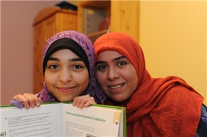 Zwei junge Frauen mit Lehrbuch