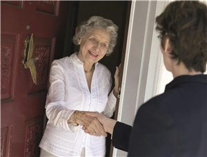 Alte Dame im Gespräch an Haustür